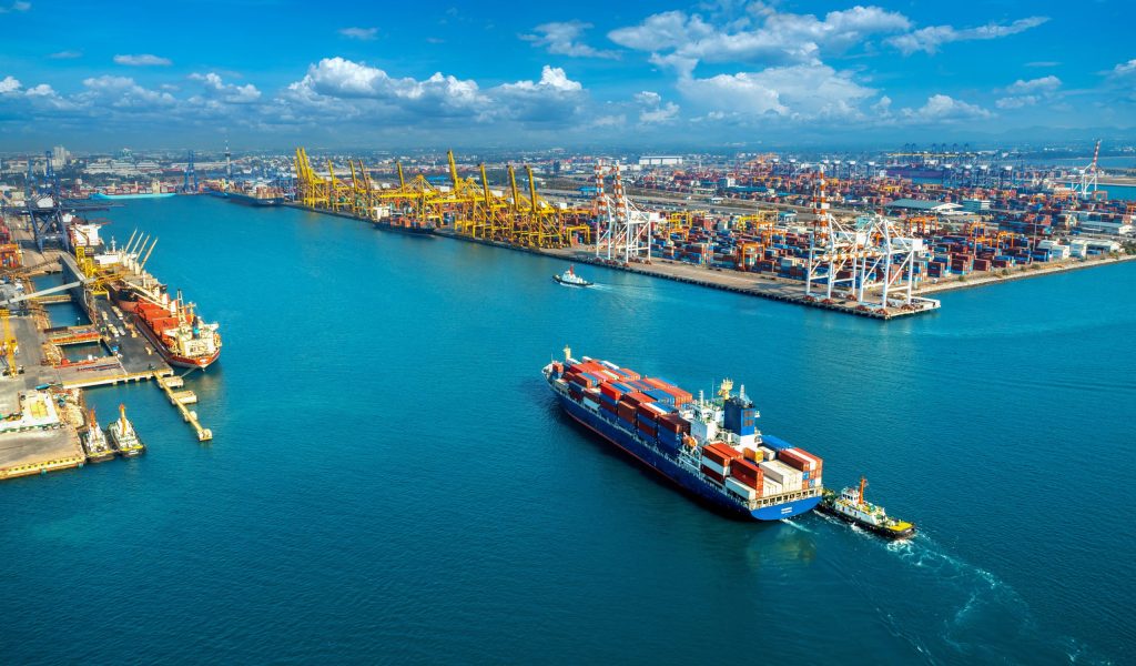 Aerial view of cargo ship and cargo container in harbor.